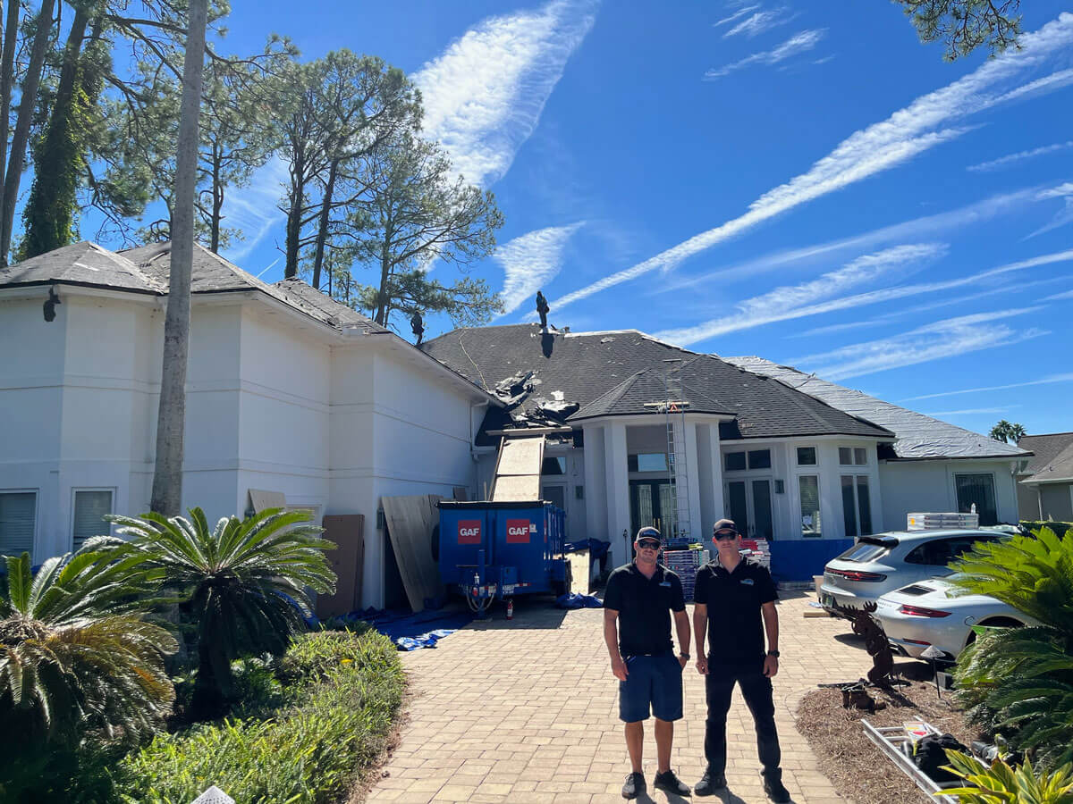 two First Light workers standing in front of home